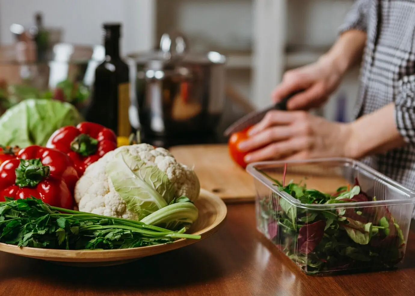 Seen from the side, a woman prepares food in the kitchen.